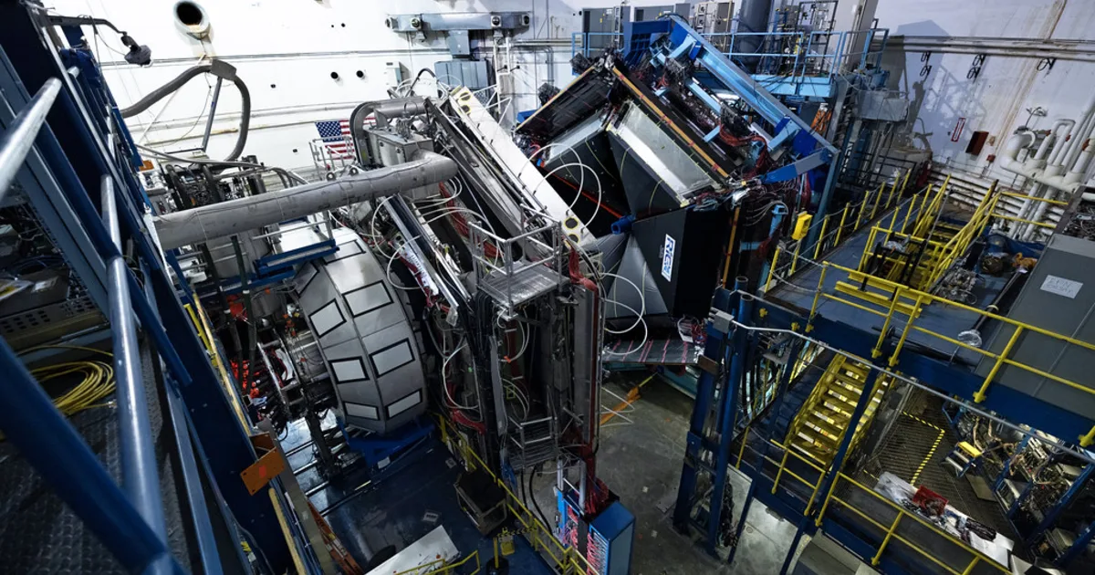 A wide-angle view inside a particle physics experiment hall, where detectors record the products of collisions.